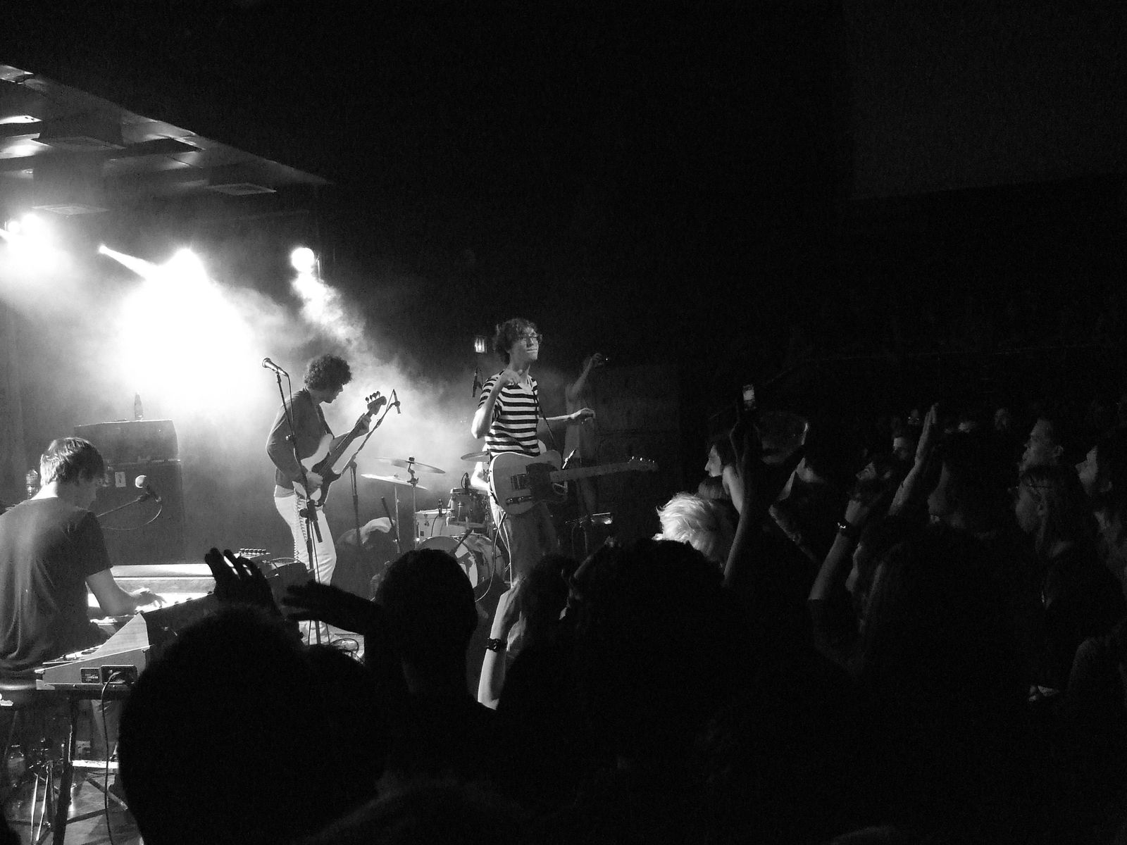 The band playing in a dark club in front of a crowd